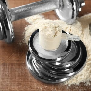 Measuring scoop with protein powder on  weight plates